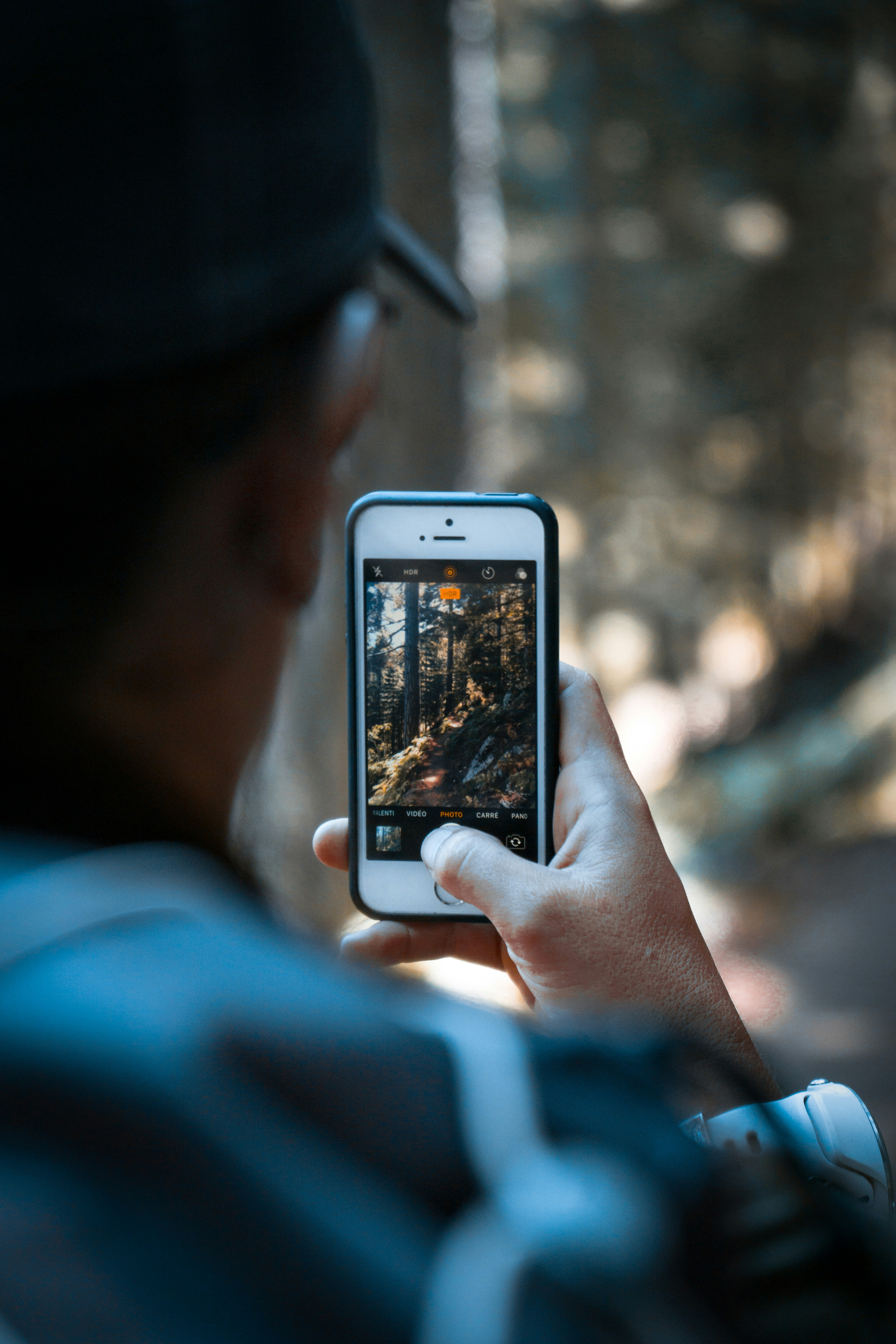 person holding silver iphone 6 with brown case